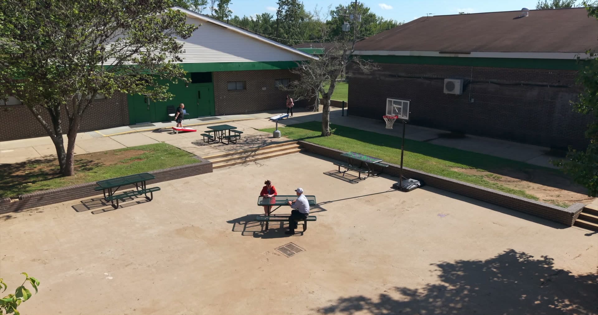 The residential campus courtyard with picnic tables and a basketball court
