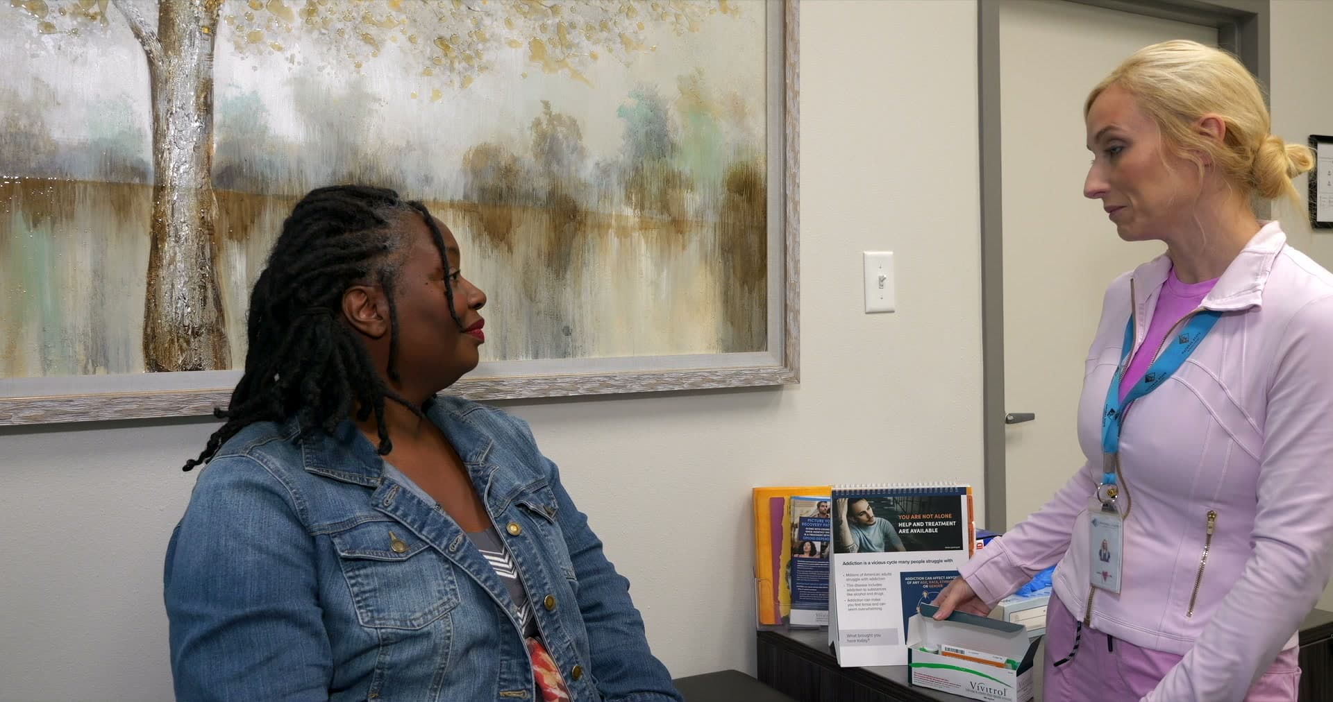 An NSRC staff member talking with a client in a treatment office